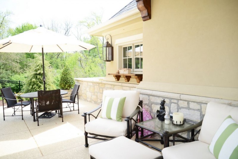 Pool house covered patio with stucco and stone wainscot