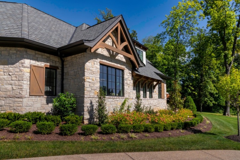 french country home design with stone timber truss accents